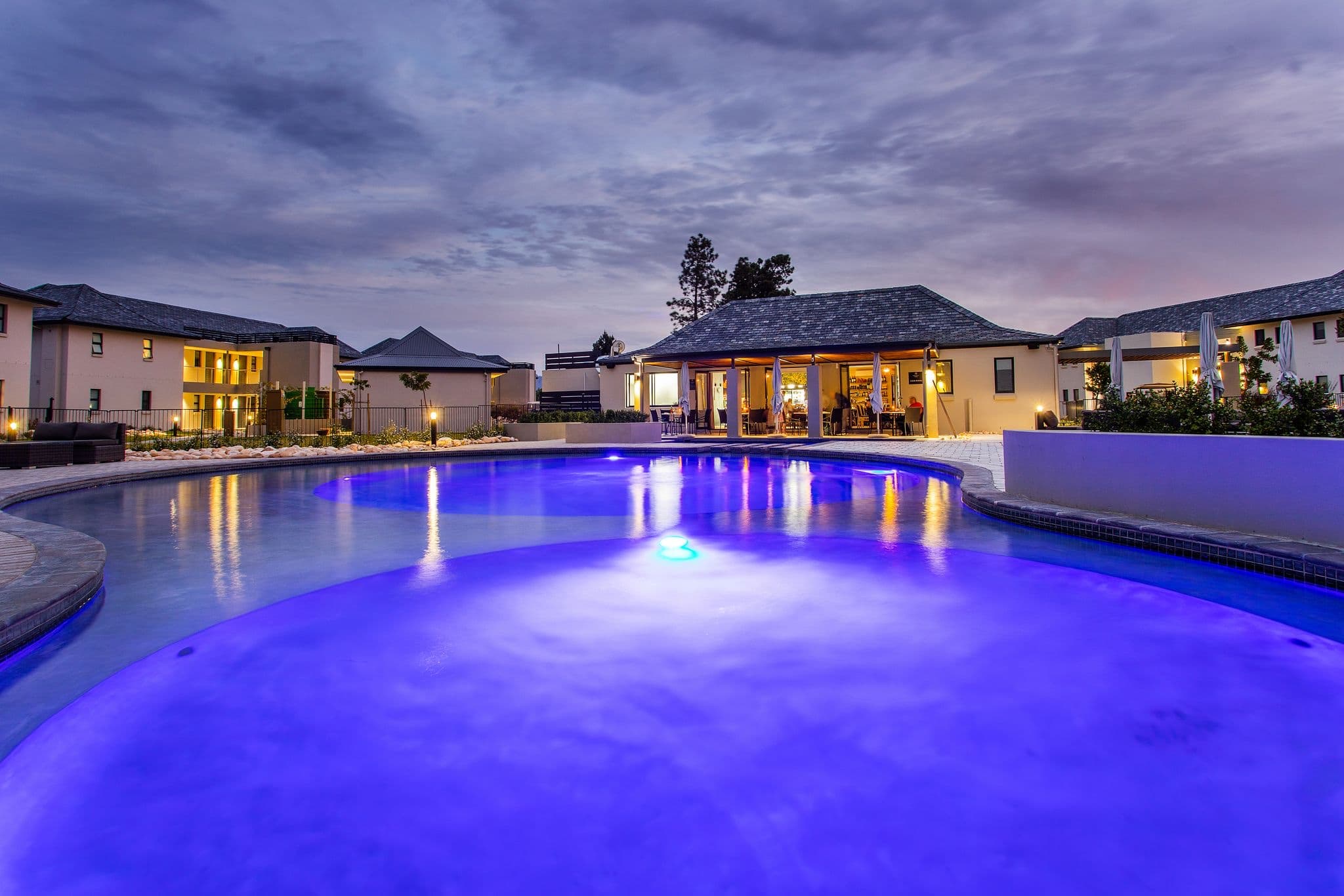 The hotel pool at dusk, with the suites behind